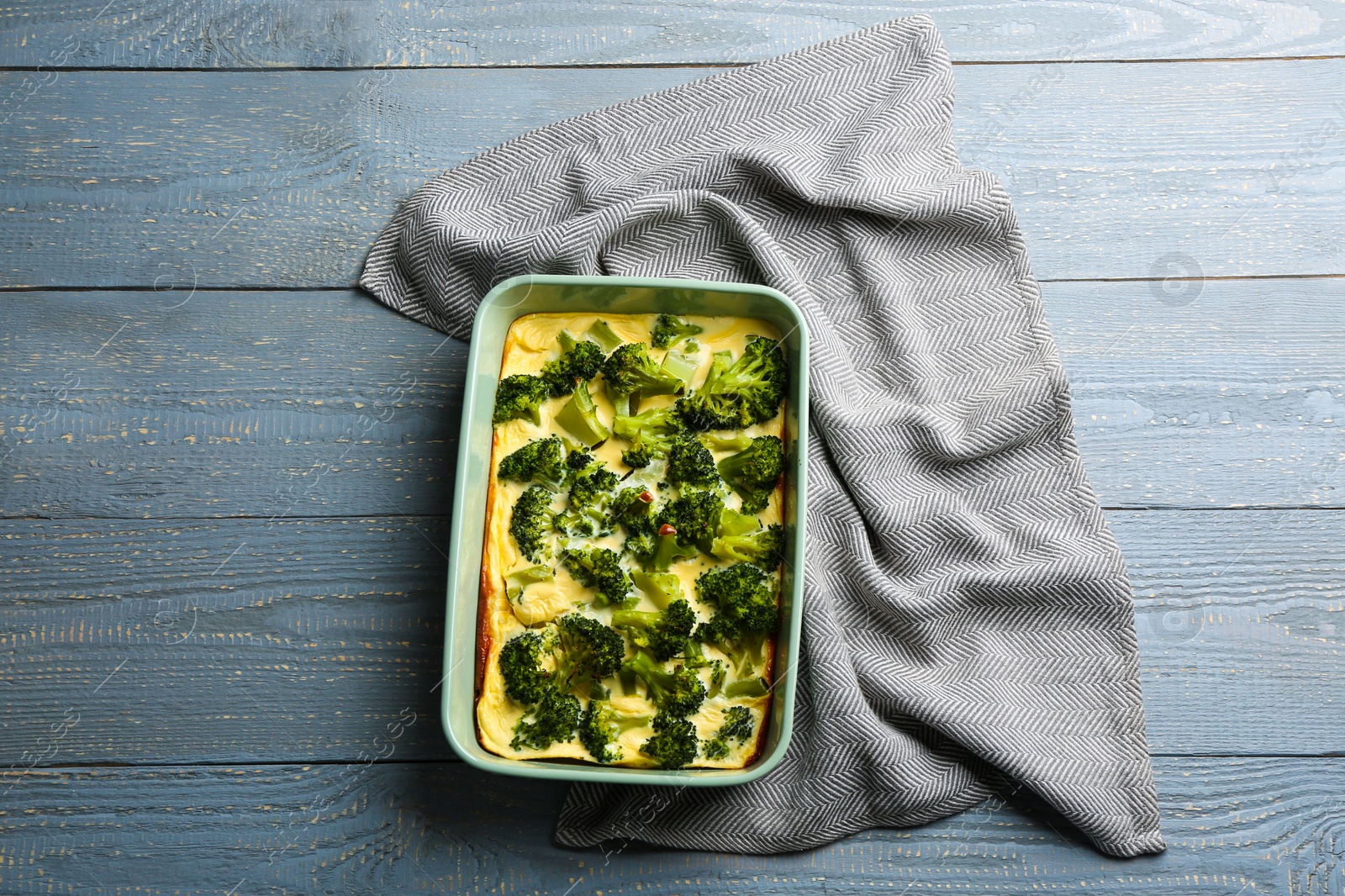 Photo of Tasty broccoli casserole in baking dish on wooden table, top view