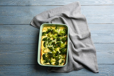 Photo of Tasty broccoli casserole in baking dish on wooden table, top view