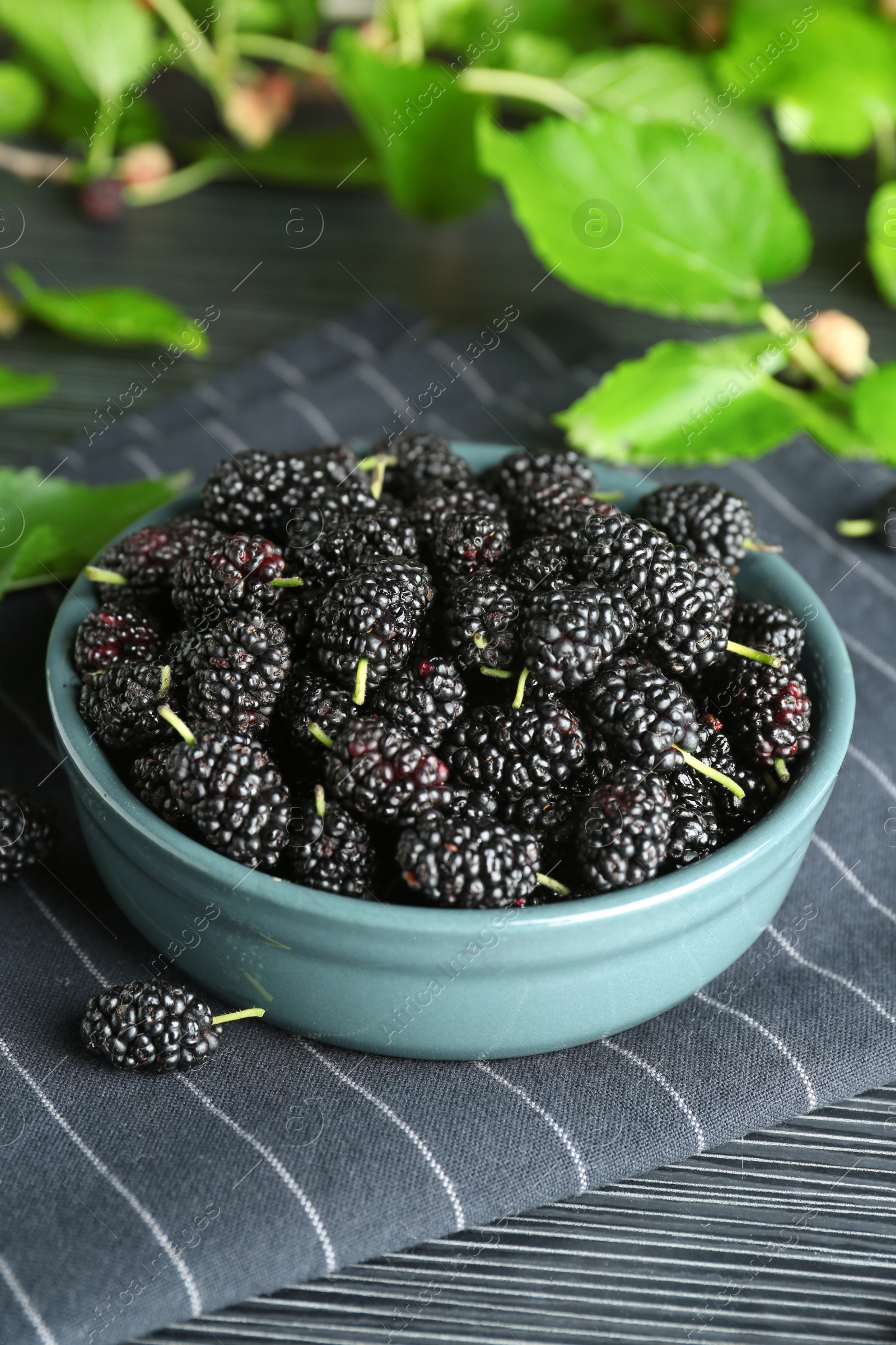 Photo of Delicious ripe black mulberries on dark wooden table