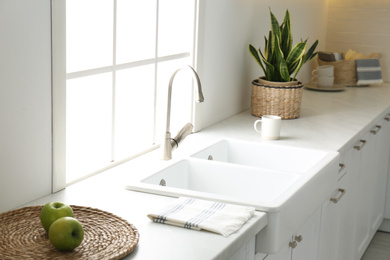 Photo of New ceramic sink and modern tap in stylish kitchen interior