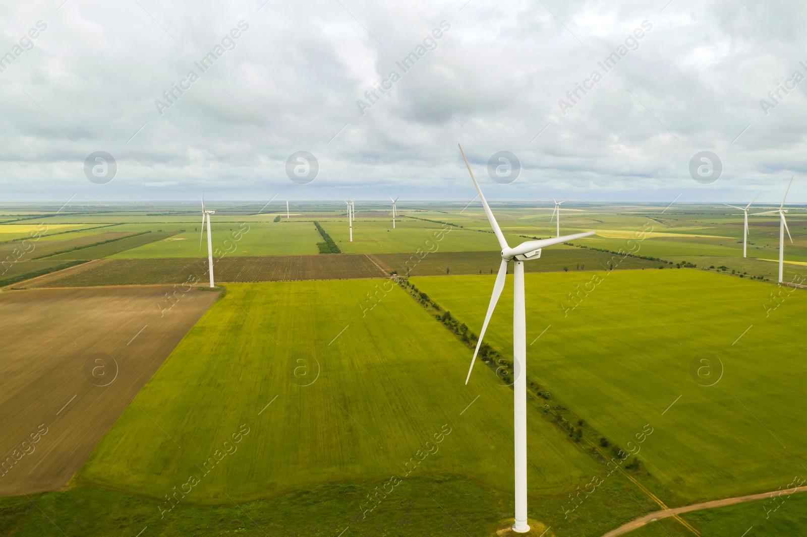 Image of Aerial view of wind turbines in field on cloudy day