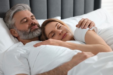 Photo of Lovely mature couple sleeping together in bed at home