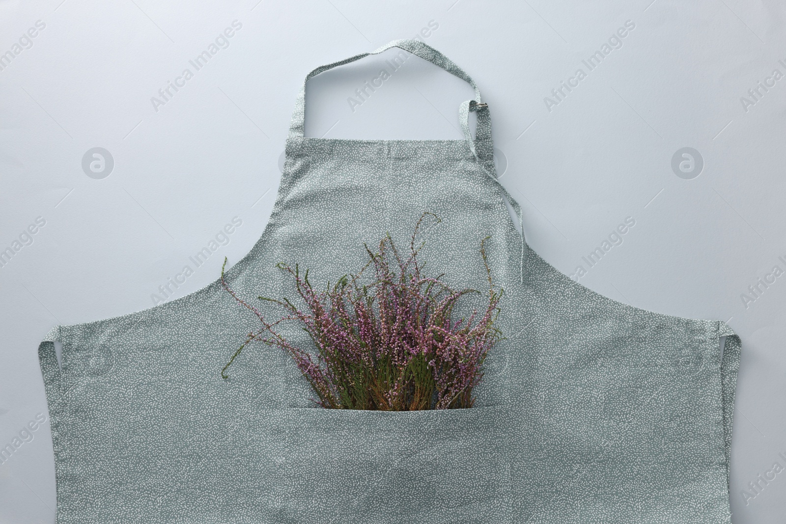 Photo of Clean kitchen apron with beautiful flowers on light grey background, top view