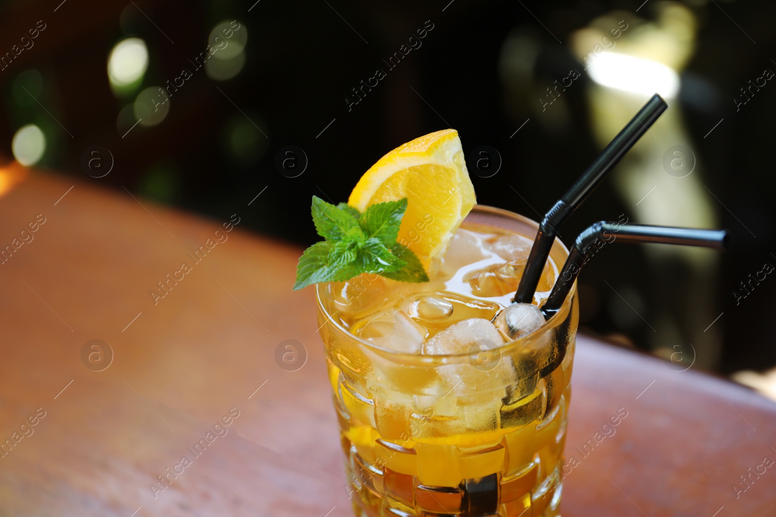 Photo of Glass of delicious cocktail with ice on table, closeup