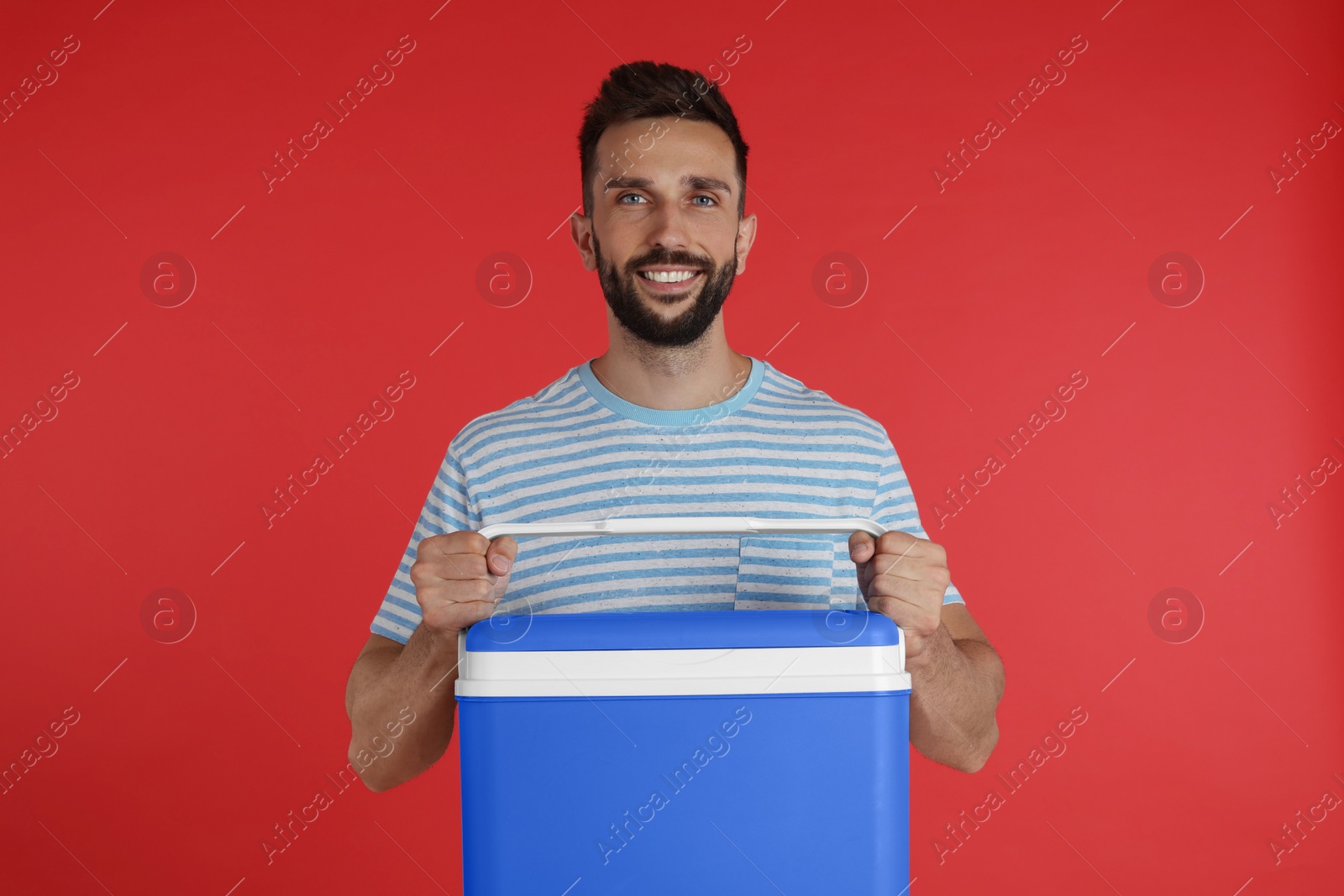 Photo of Happy man with cool box on red background