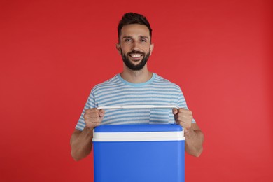 Happy man with cool box on red background