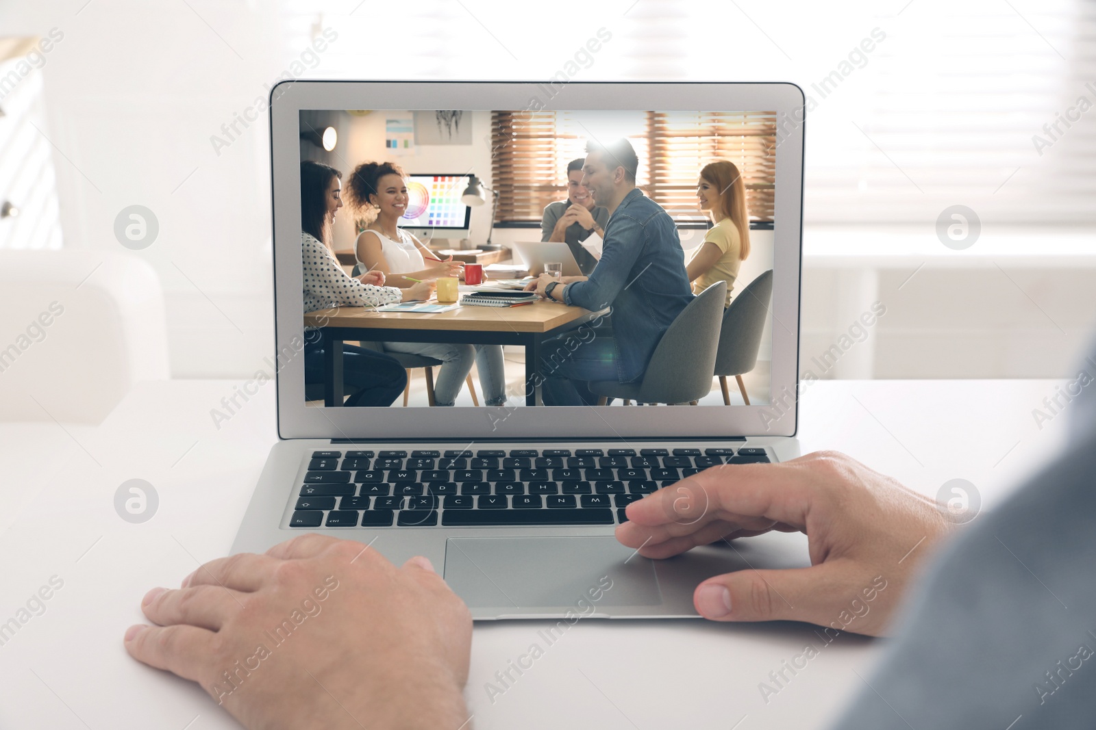 Image of Man attending online video conference via modern laptop at table, closeup