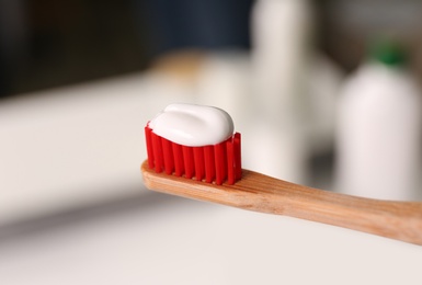 Photo of Toothbrush with paste on blurred background, closeup