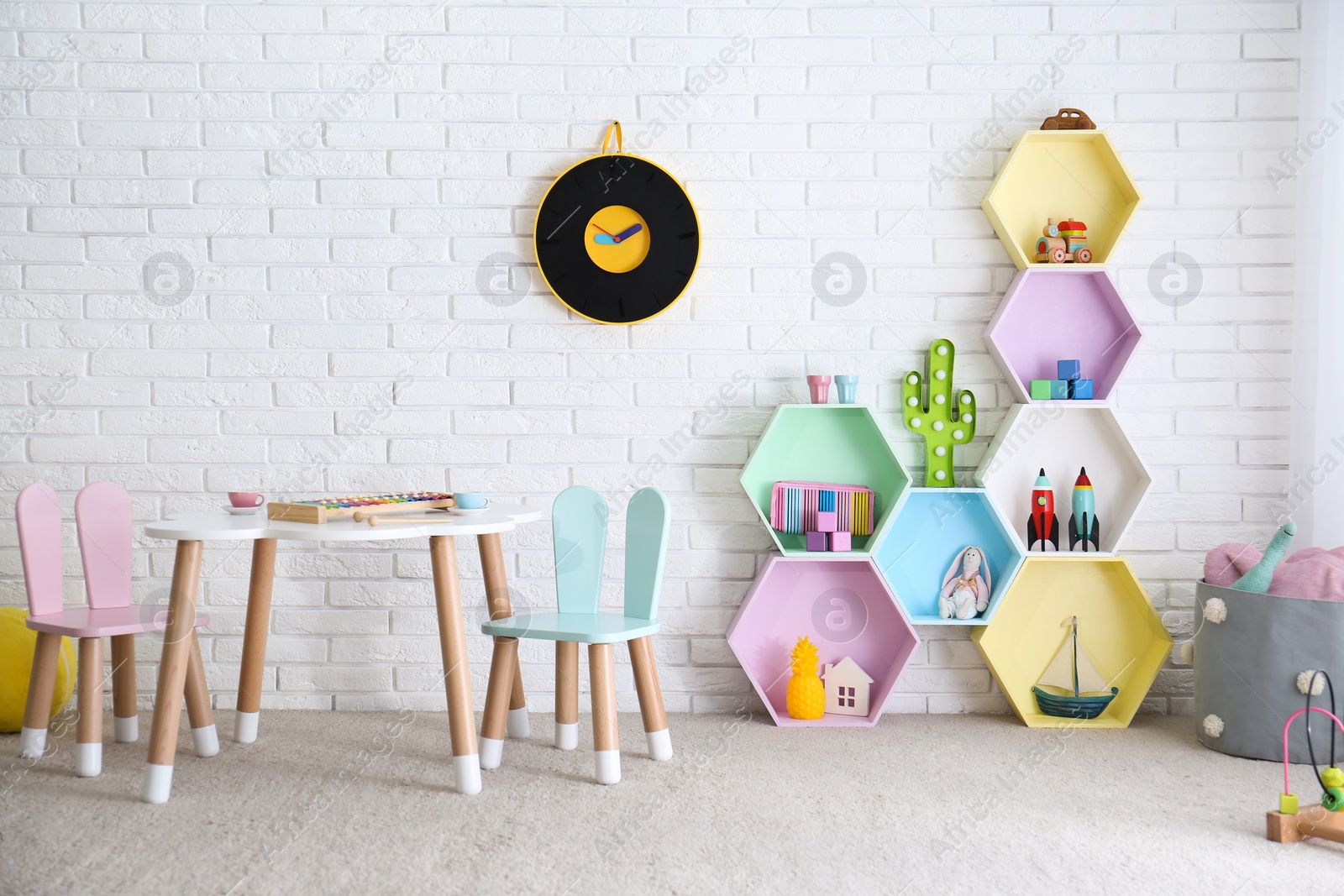 Photo of Child room interior with colorful shelves near brick wall