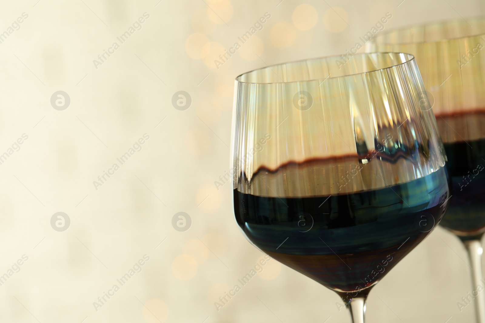 Photo of Glasses of red wine on light background, closeup. Space for text