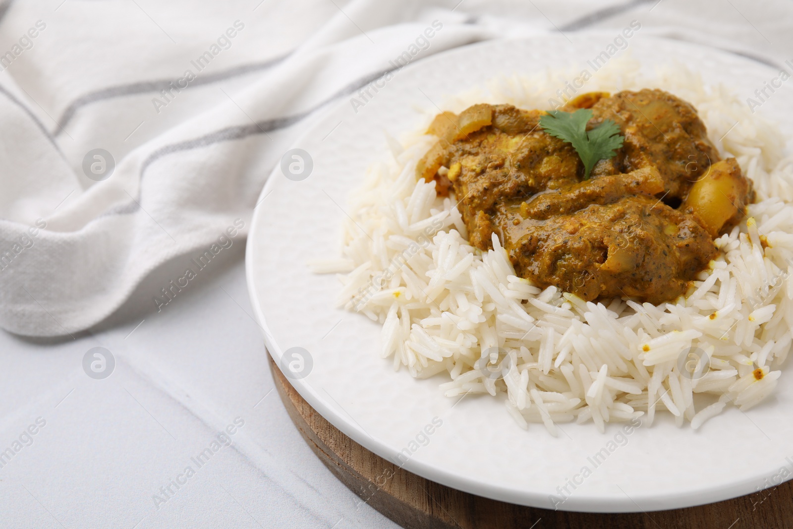 Photo of Delicious chicken curry with rice on white tiled table, closeup