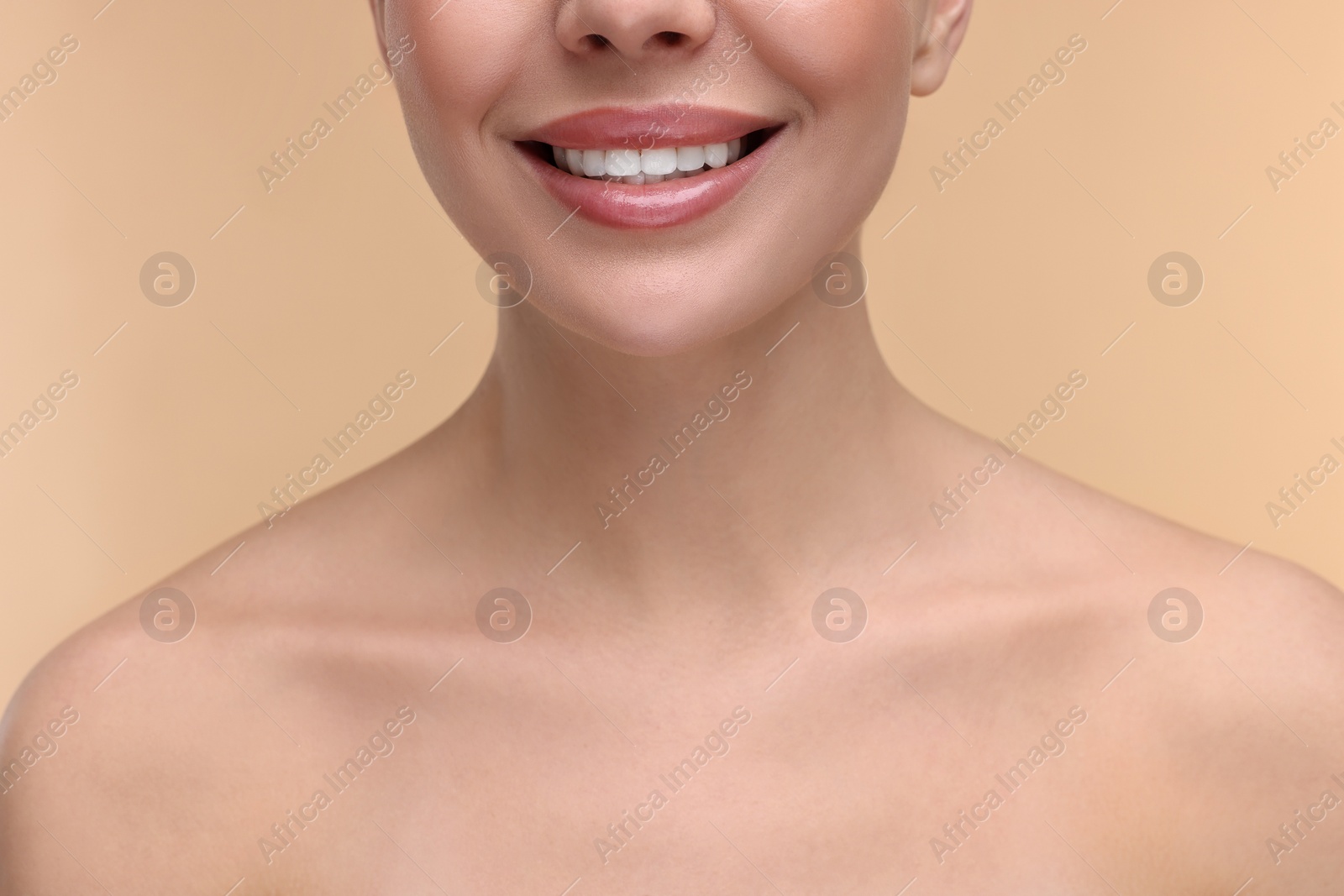 Photo of Woman with beautiful lips smiling on beige background, closeup