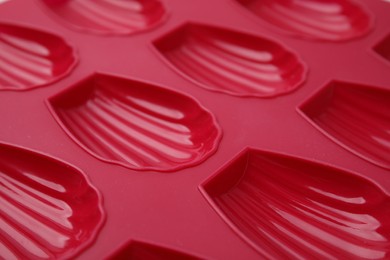 Photo of Red baking mold for madeleine cookies as background, closeup