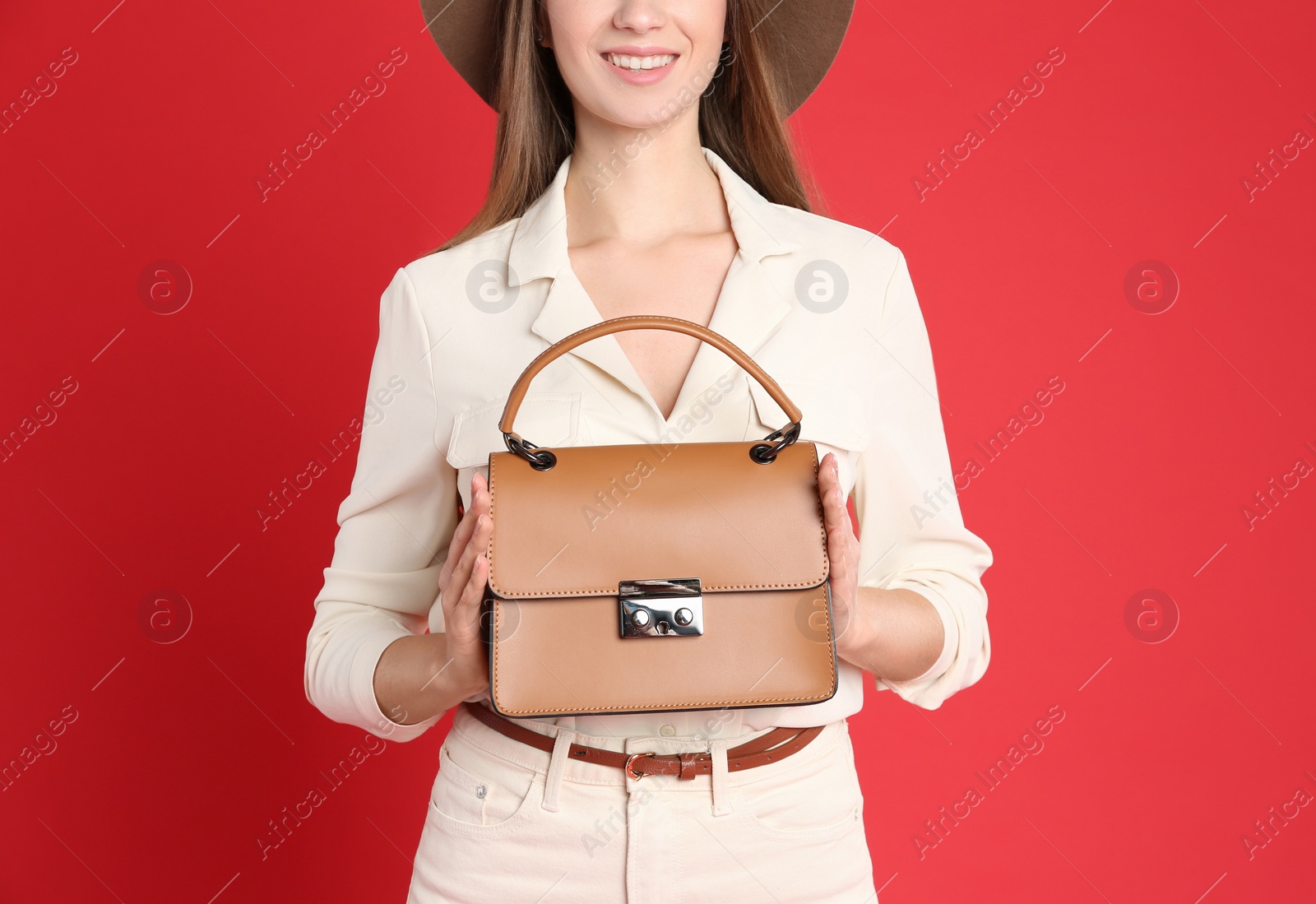 Photo of Young woman in casual outfit with stylish bag on red background, closeup