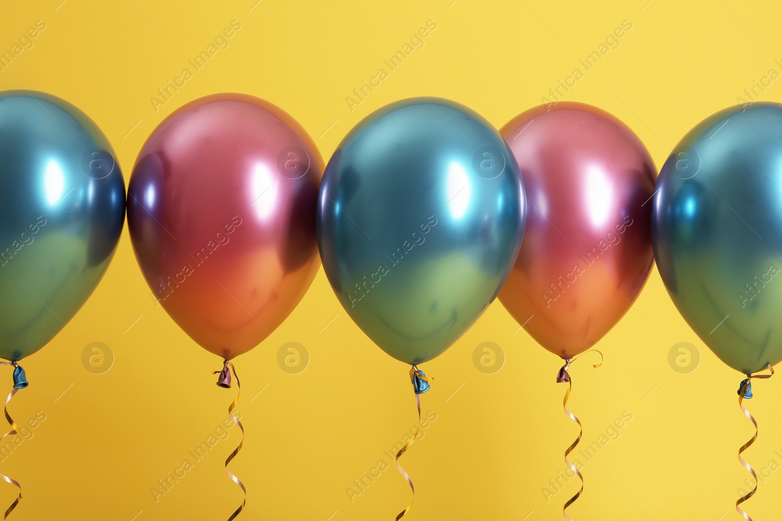 Photo of Bright balloons with ribbons on color background