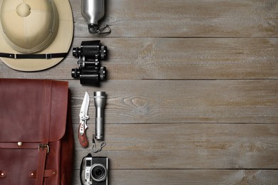 Flat lay composition with different safari accessories on wooden background, space for text