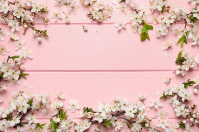 Frame of beautiful spring flowers on pink wooden background, flat lay. Space for text