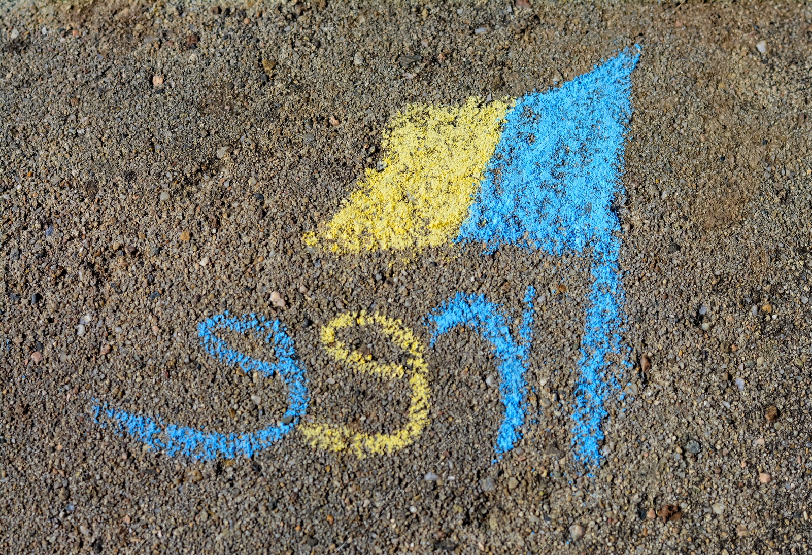 Photo of National flag of Ukraine with word Free drawn by blue and yellow chalk on asphalt, top view