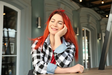 Photo of Young woman with bright dyed long hair outdoors