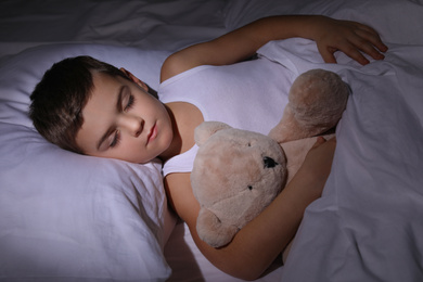 Little boy sleeping with teddy bear at home. Bedtime