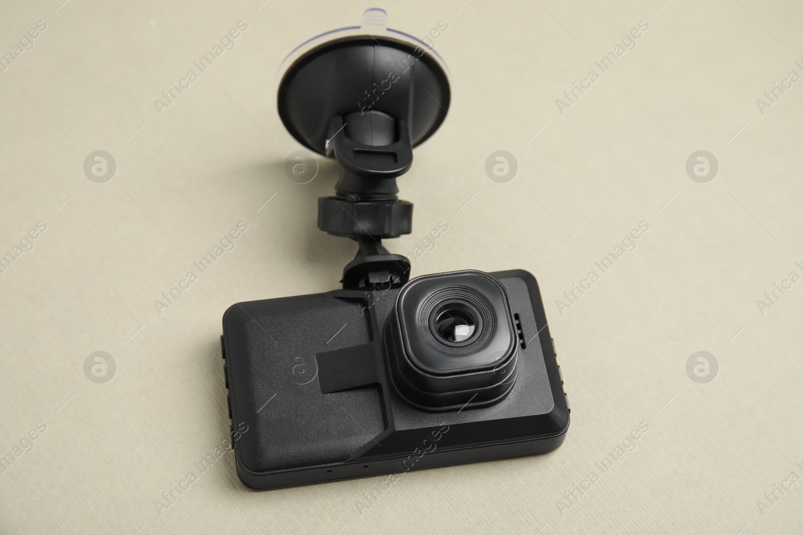 Photo of Modern car dashboard camera with suction mount on light background