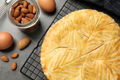 Traditional galette des rois and ingredients on grey table, flat lay