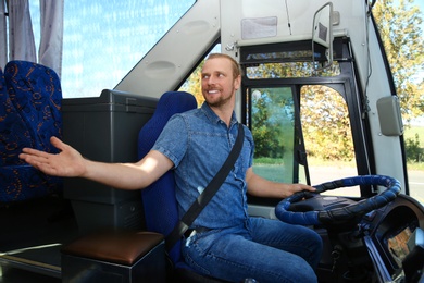 Photo of Professional bus driver at steering wheel. Passenger transportation