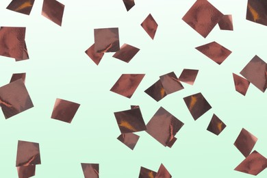 Image of Shiny bronze confetti falling on light green background
