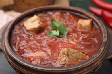 Photo of Tasty borscht in bowl on table, closeup
