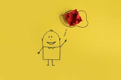 Photo of Drawn human and speech bubble with red paper flower as solution idea on yellow background, flat lay