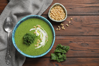 Tasty kale soup served on wooden table, flat lay