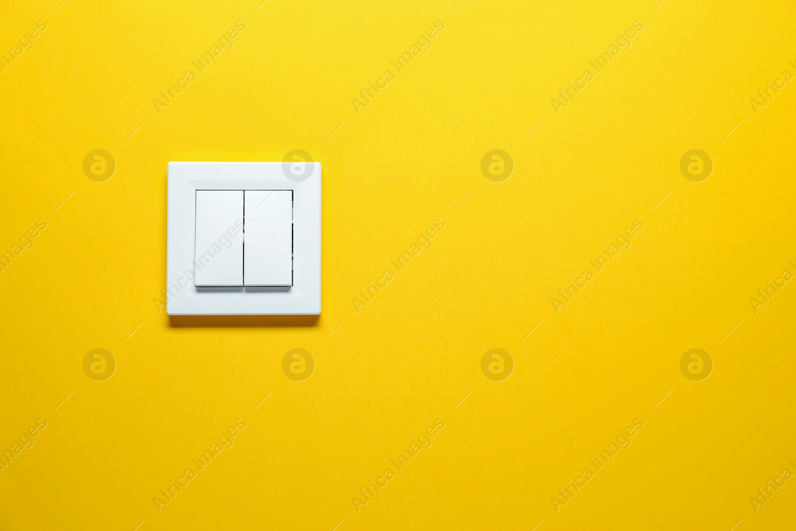 Photo of Modern plastic light switch on orange background. Space for text