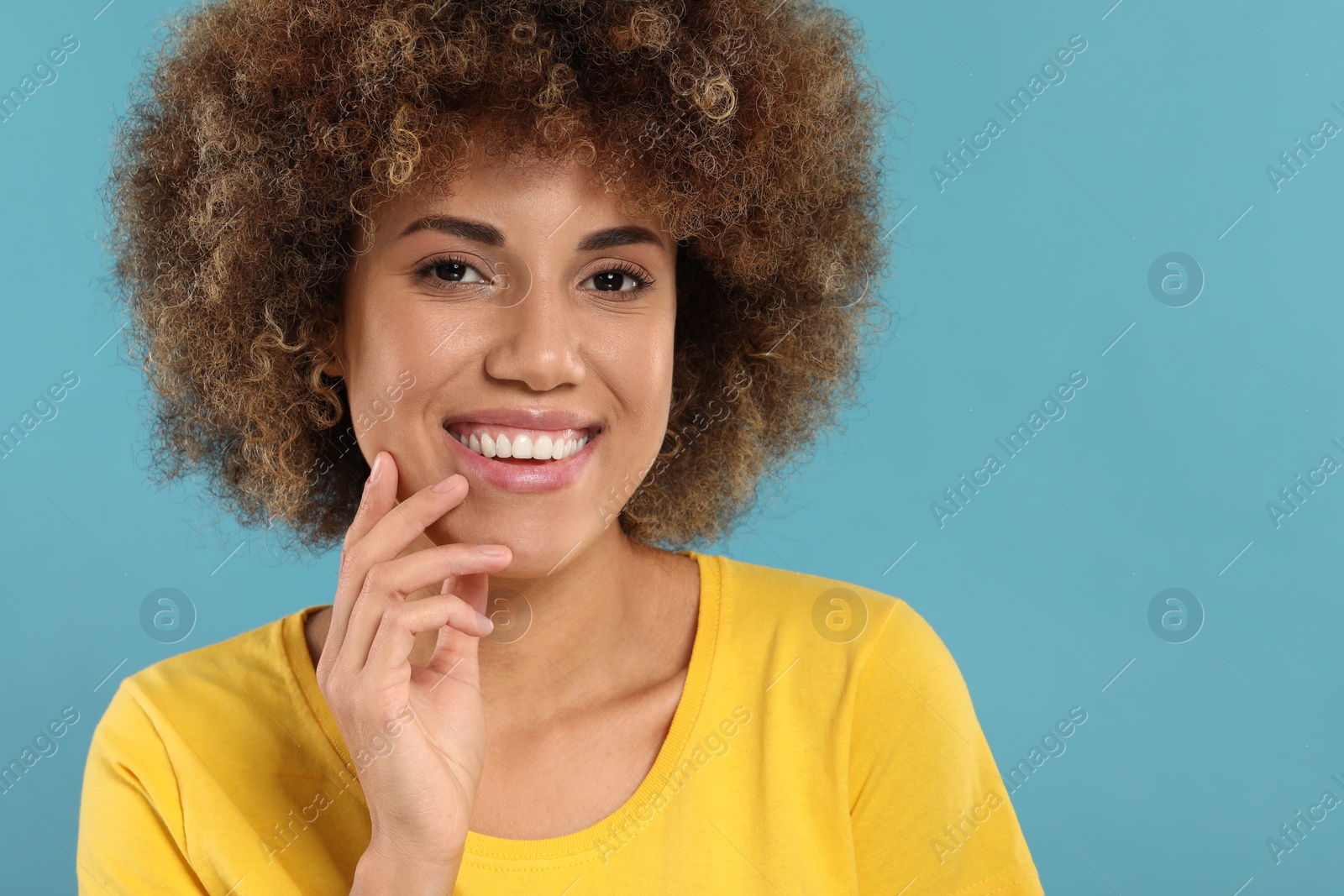 Photo of Woman with clean teeth smiling on light blue background, space for text