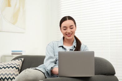 Woman using laptop on couch at home