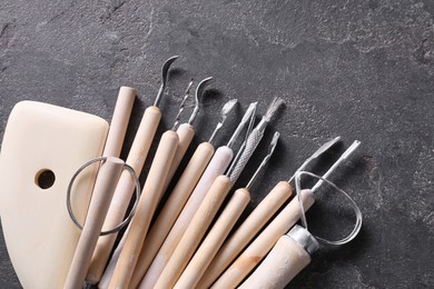 Set of different clay crafting tools on grey table, top view