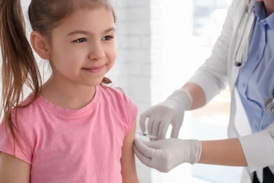 Doctor vaccinating little girl in hospital