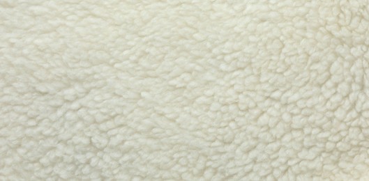 Texture of white fleece fabric as background, top view