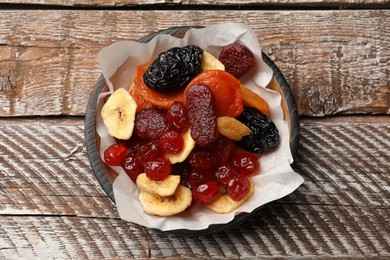 Photo of Mix of delicious dried fruits on wooden table, top view