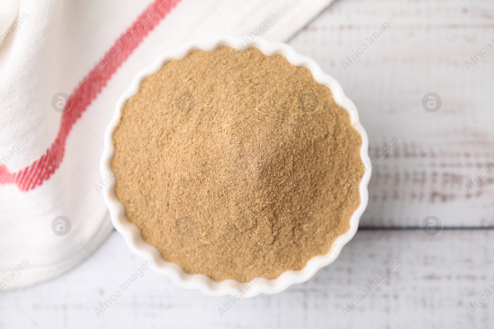 Photo of Dietary fiber. Psyllium husk powder in bowl on wooden table, top view