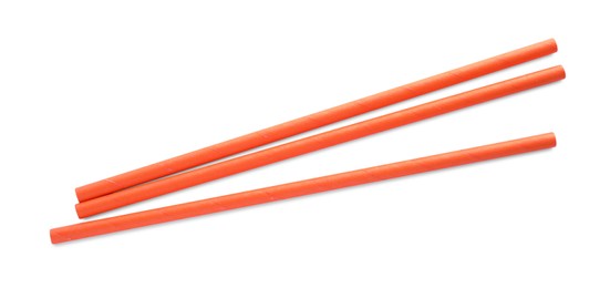 Photo of Orange paper cocktail straws on white background, top view