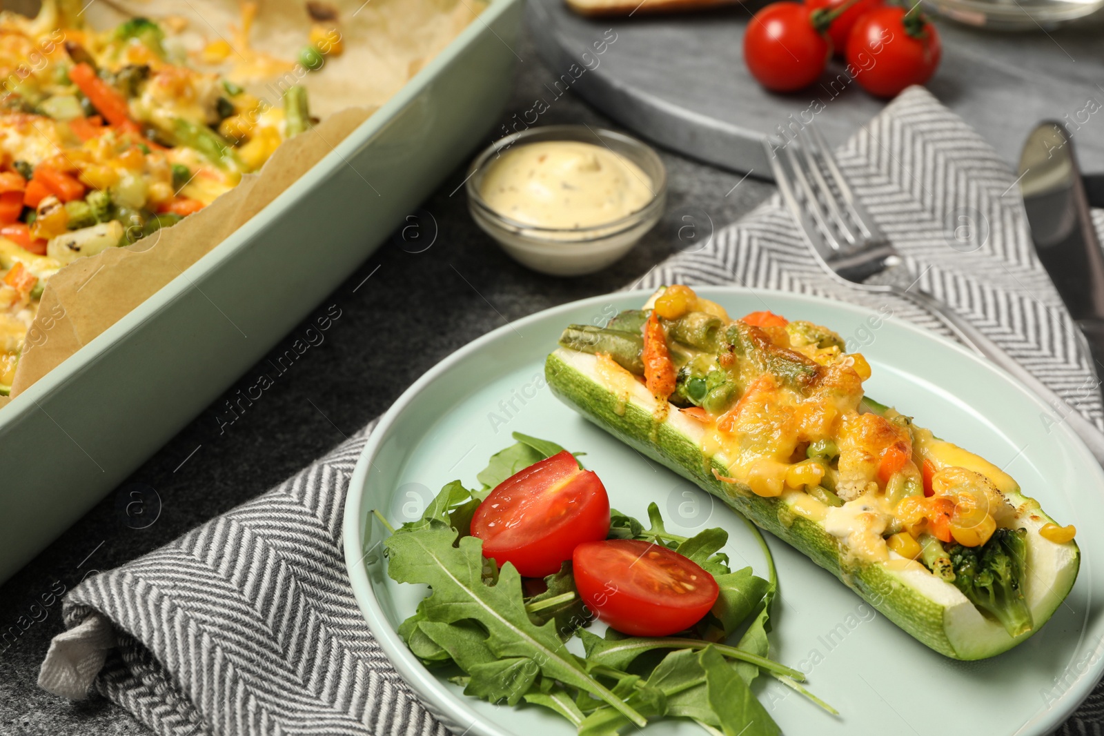 Photo of Baked stuffed zucchinis served on grey table, closeup view