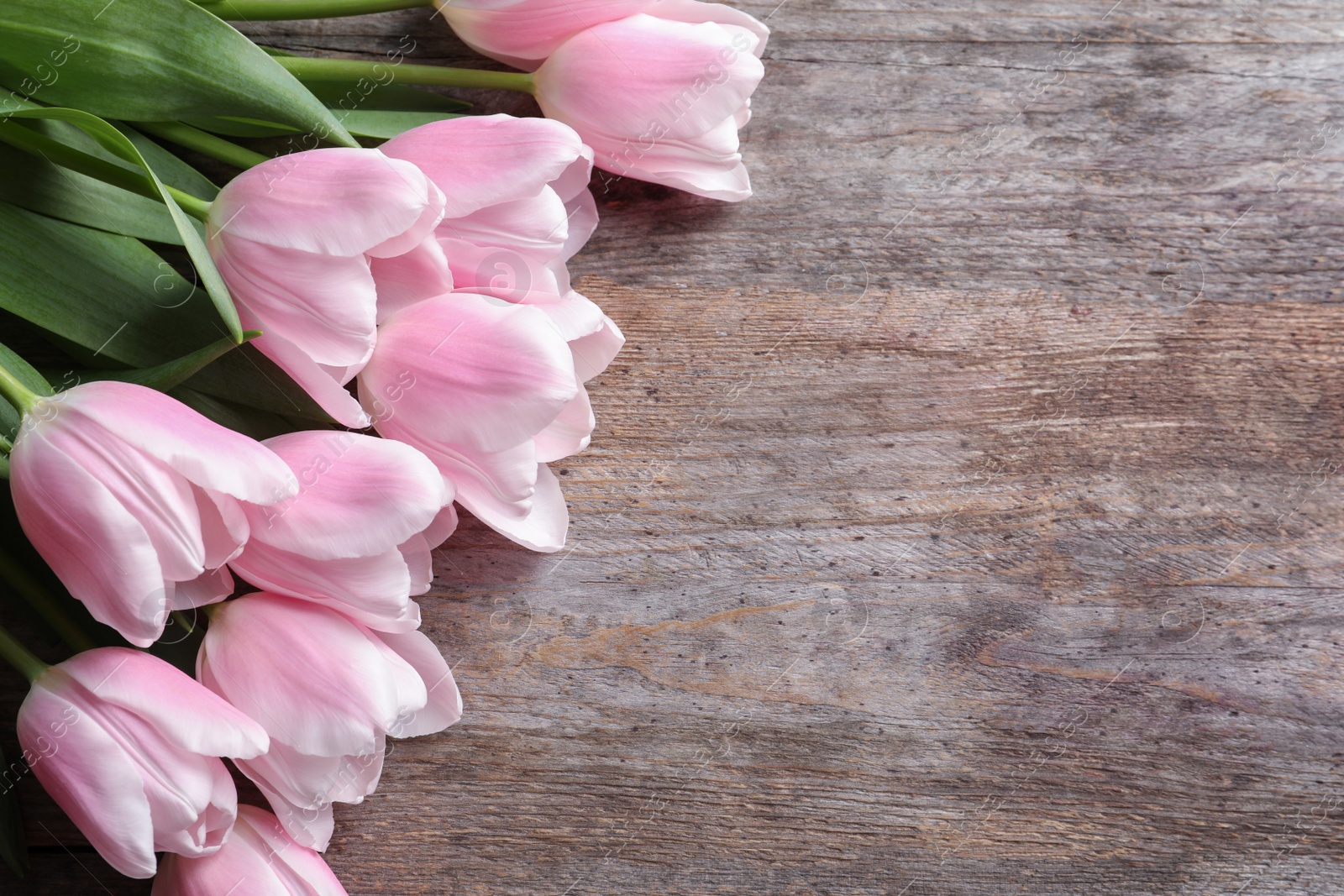 Photo of Beautiful tulips for Mother's Day on wooden background, top view