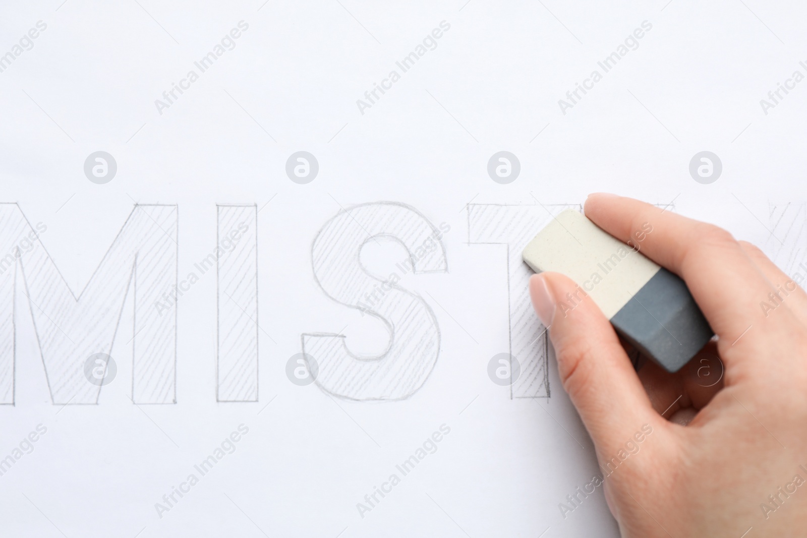 Photo of Woman erasing word on sheet of white paper, top view
