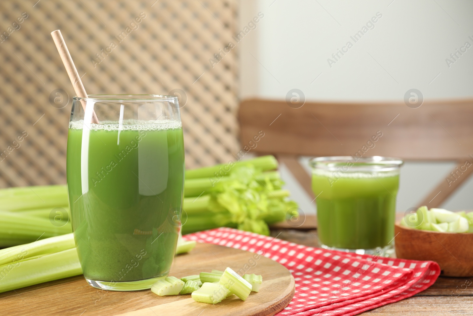 Photo of Glass of delicious celery juice and vegetables on wooden table, closeup. Space for text