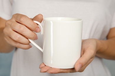 Photo of Woman holding ceramic cup, closeup. Mock up for design