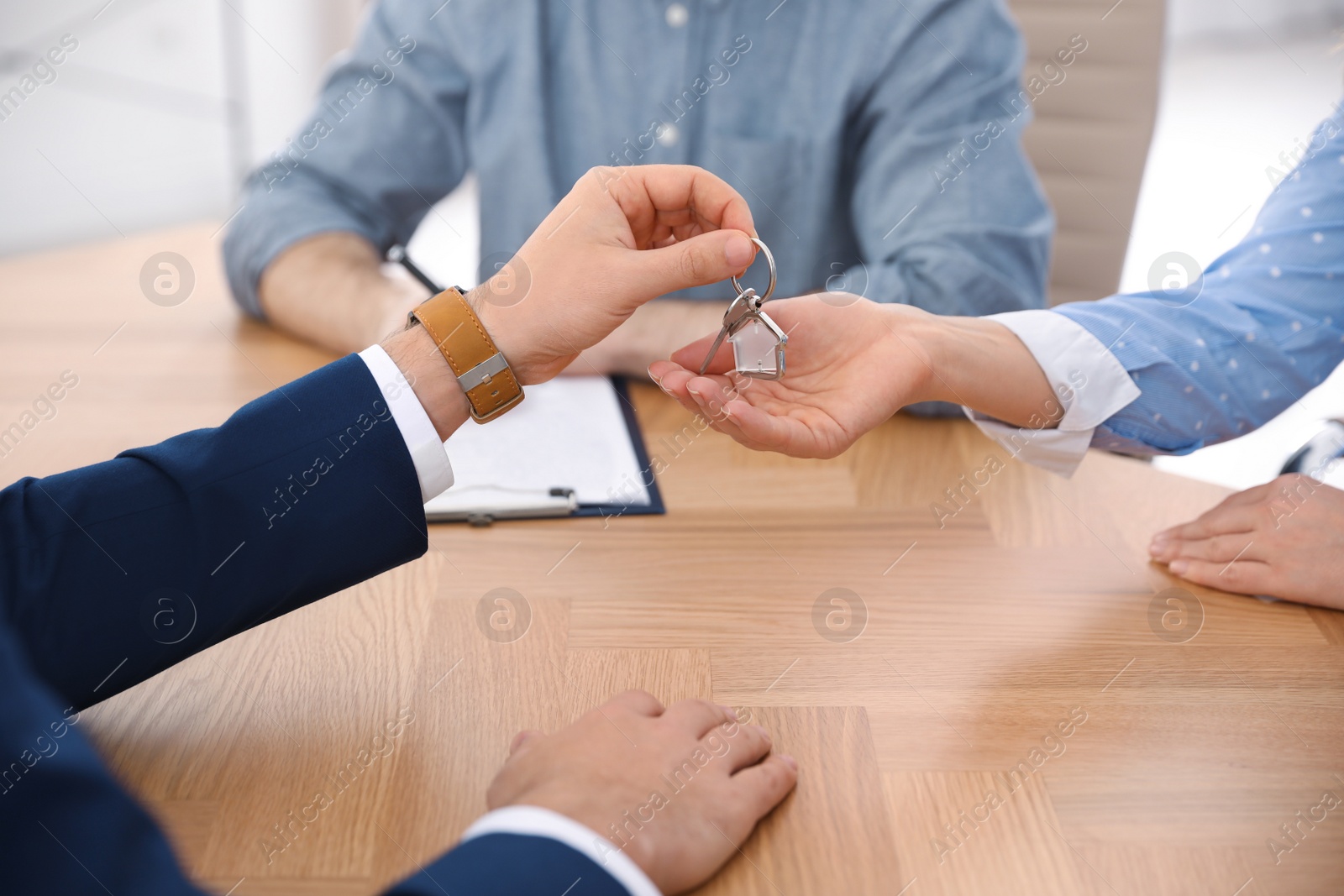 Photo of Real estate agent working with clients in office, closeup