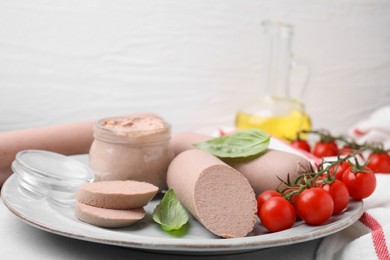 Delicious liver sausages, paste and cherry tomatoes on light grey table