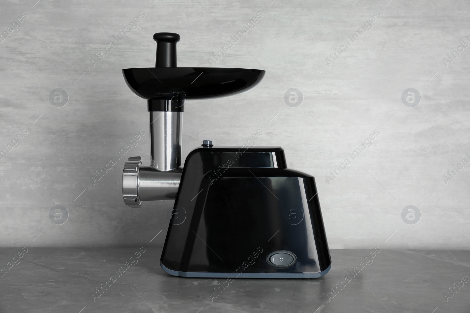 Photo of Modern electric meat grinder on grey table