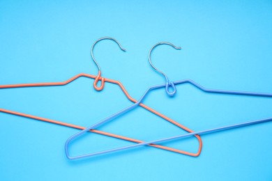 Photo of Empty hangers on light blue background, top view