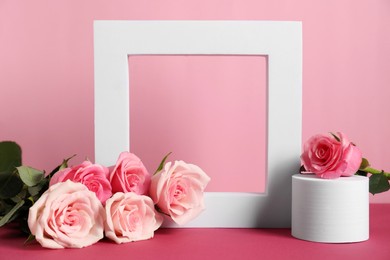 Photo of Stylish presentation of product. Beautiful roses and geometric figures on pink table